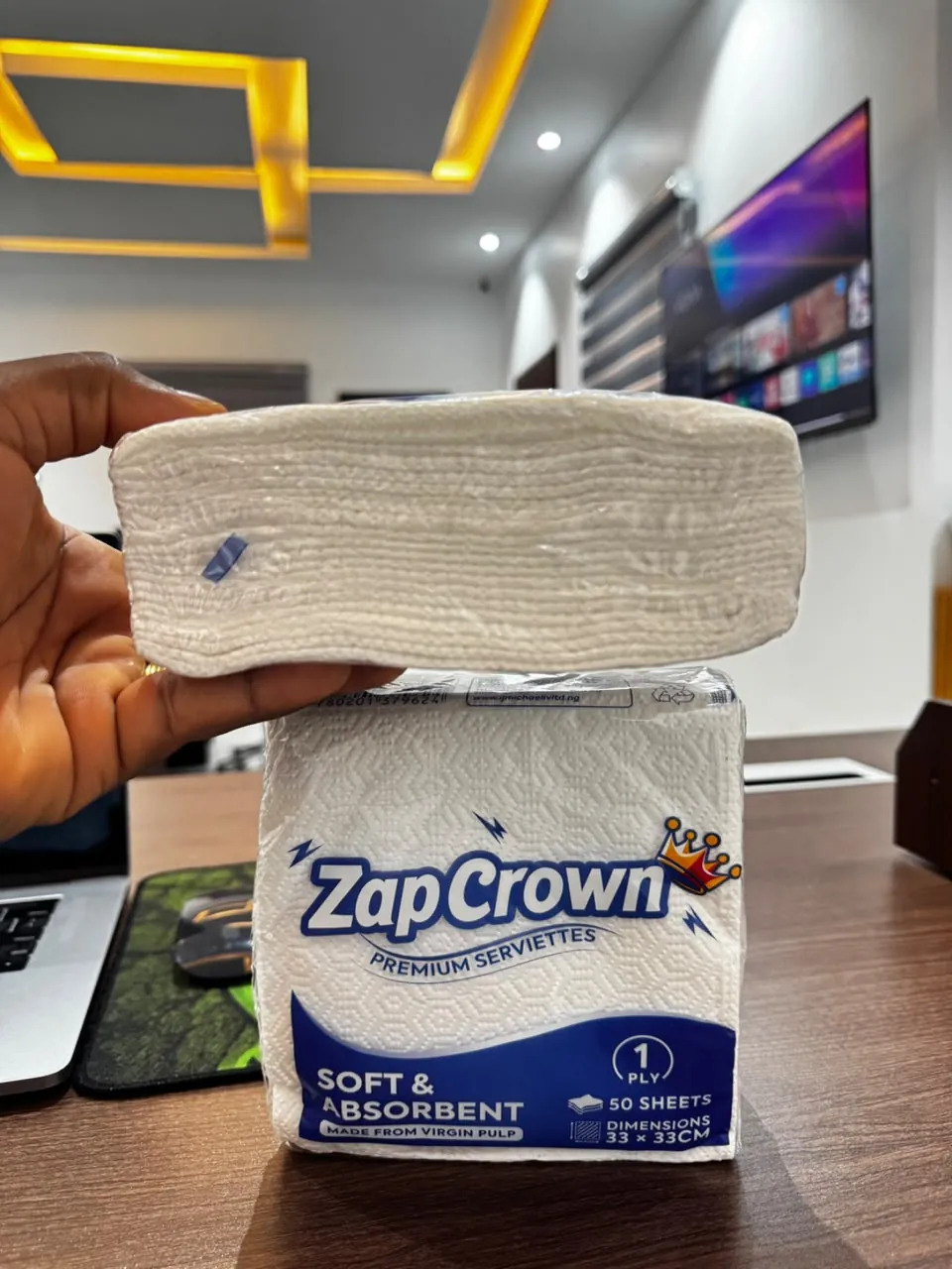 A hand lifting ZapCrown serviettes from their pack